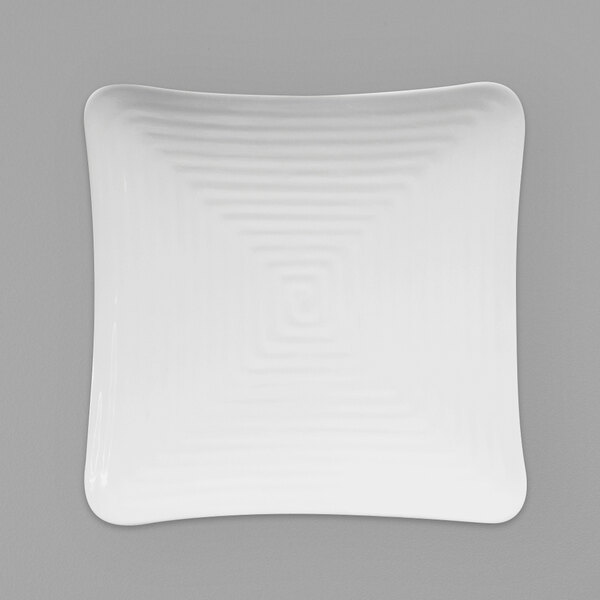 A white square plate with a spiral pattern.