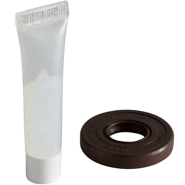 A plastic tube with a white cap and a brown round object with a hole in the middle.