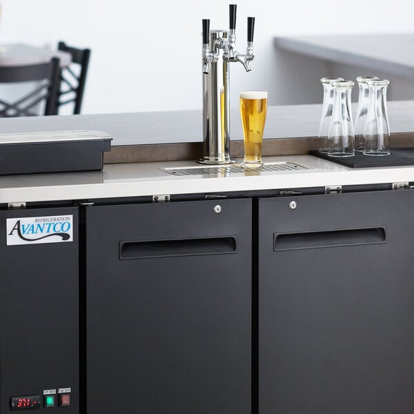 An Avantco black beer dispenser with two taps on a counter.