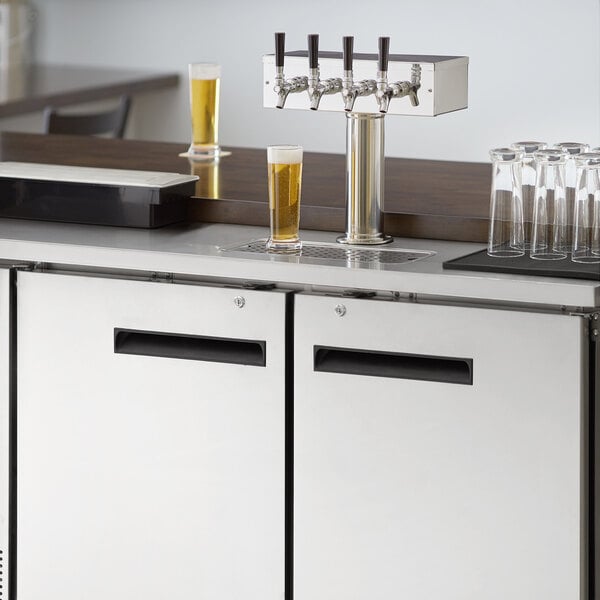 An Avantco stainless steel beer dispenser on a counter with beer taps.