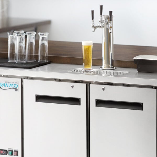 An Avantco stainless steel beer dispenser on a counter with taps.