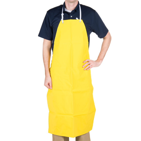 A man wearing a yellow San Jamar dishwasher apron.