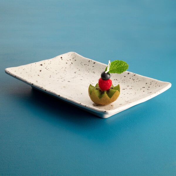 A rectangular chocolate chip melamine plate with fruit on it.
