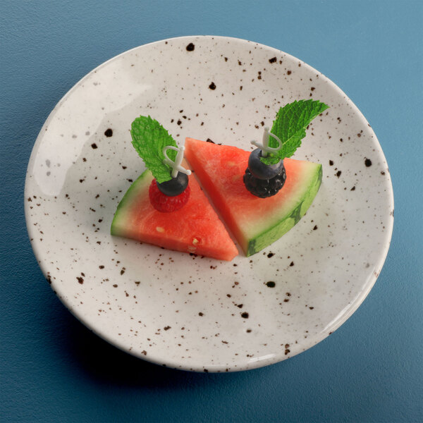 A Elite Global Solutions chocolate chip melamine plate with a slice of watermelon, blueberries, and mint leaves.