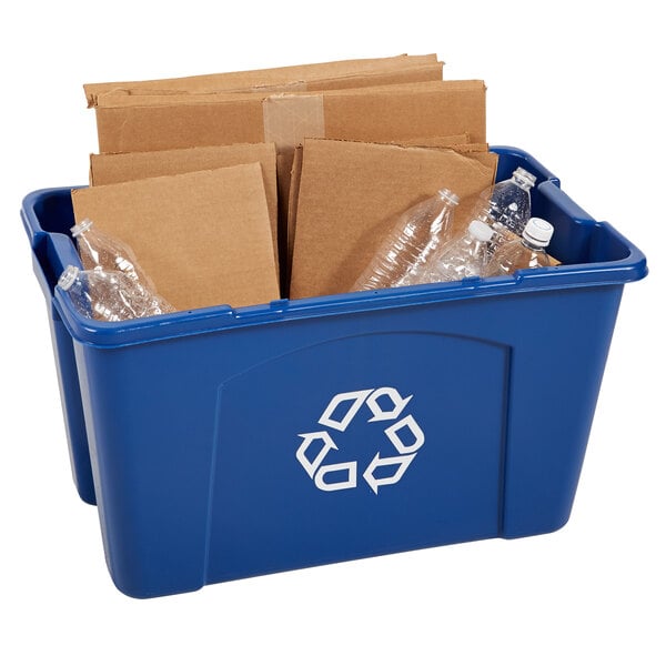 A blue Rubbermaid rectangular recycling bin full of plastic bottles and cardboard.