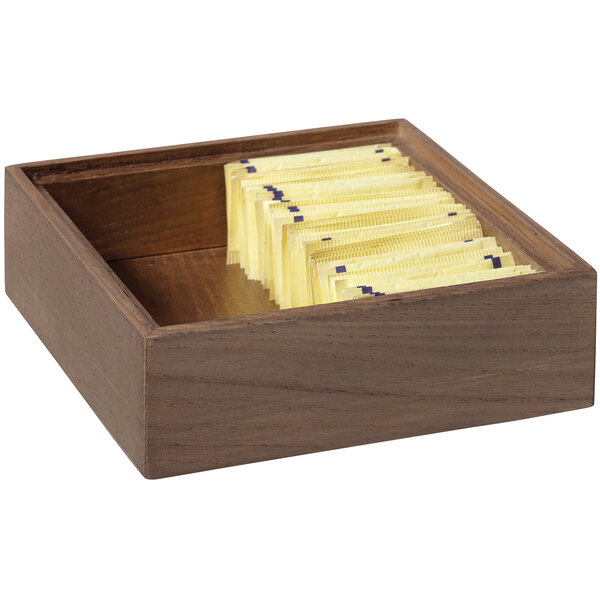 A gray wooden square display box with yellow packets in it.