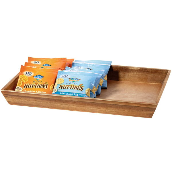 A wooden tray with several bags of snacks including chips.