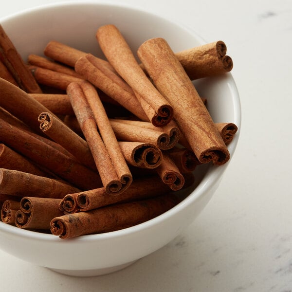 A bowl of Regal cinnamon sticks on a table.