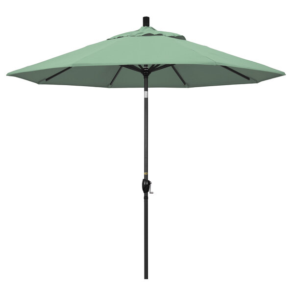 A green California Umbrella on a black stand.