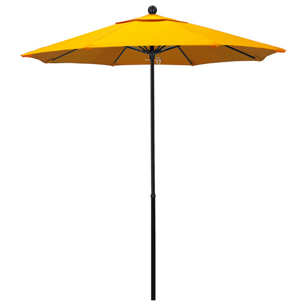 A Sunbrella yellow umbrella on a black pole.