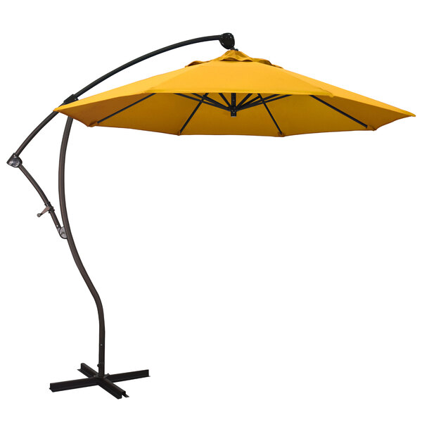 A California Umbrella Bayside cantilever umbrella with a yellow Pacifica canopy on a stand.
