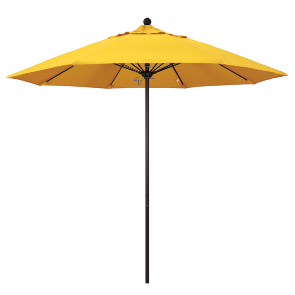 A yellow California Umbrella on a bronze pole.