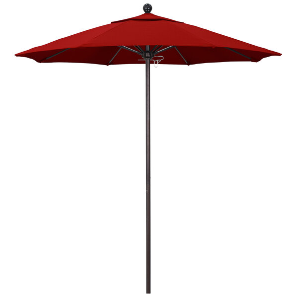 A red California Umbrella on a bronze pole.
