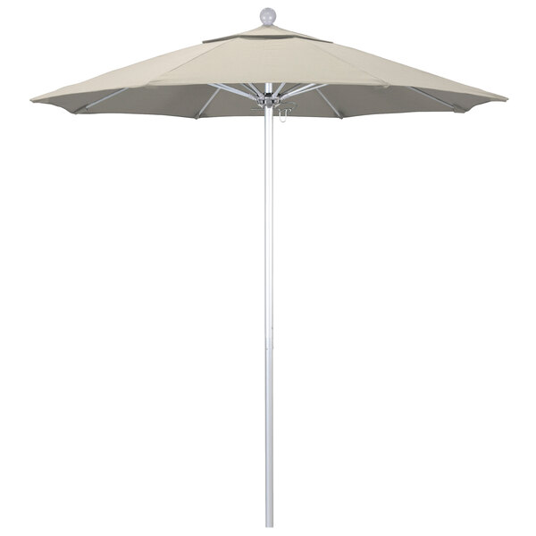 A large beige California Umbrella on a silver metal pole.