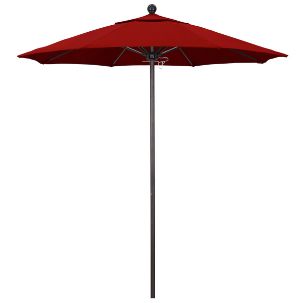 A close-up of a red California Umbrella on a bronze pole.