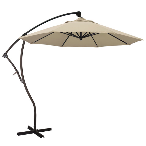 A beige California Umbrella with a Pacifica canopy on a metal stand.