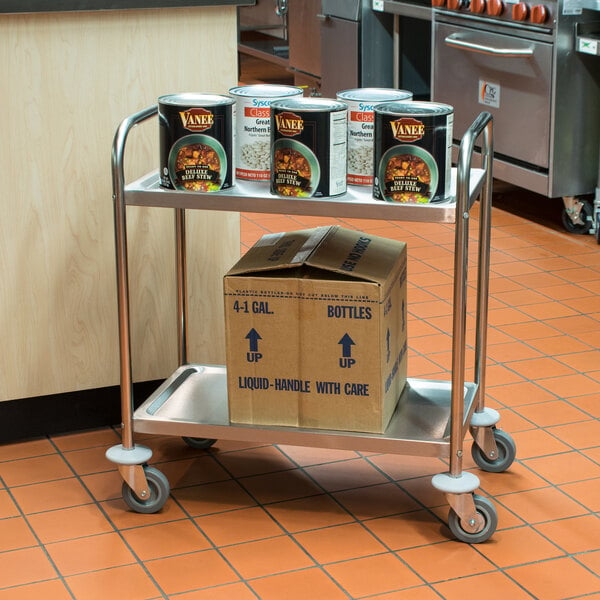 A stainless steel utility cart with cans and boxes on the shelves.