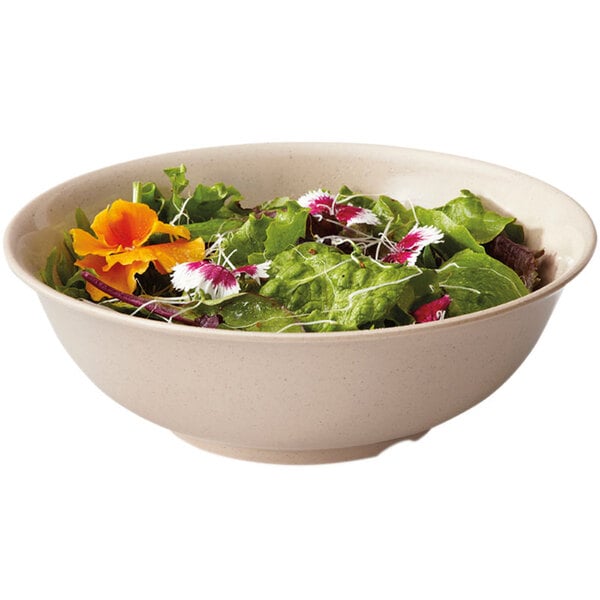 A GET Tahoe Sandstone melamine bowl filled with salad and flowers.