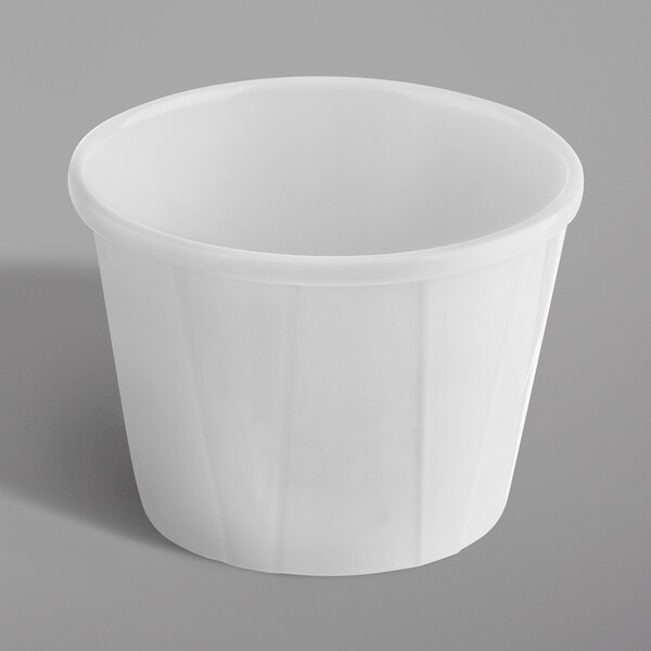 A white Tablecraft melamine souffle cup on a gray surface.