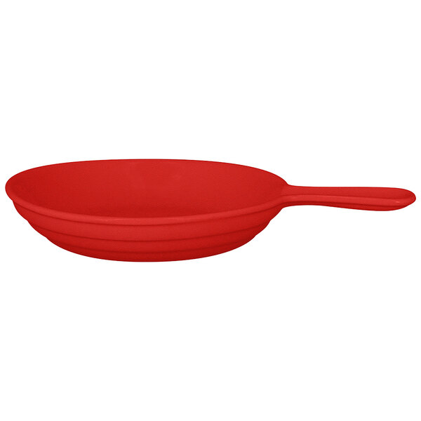A red porcelain frying pan with a handle.