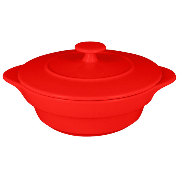 A red round porcelain cocotte with a lid.