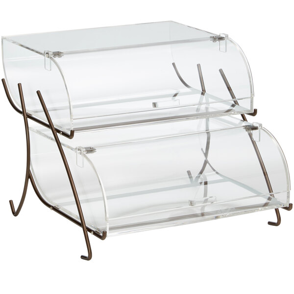 A clear acrylic two-tier pastry display case with bronze wire stand.