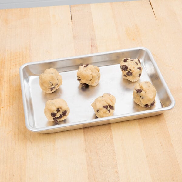 A tray of Chicago Metallic aluminum sheet pan chocolate chip cookies on a wood table.