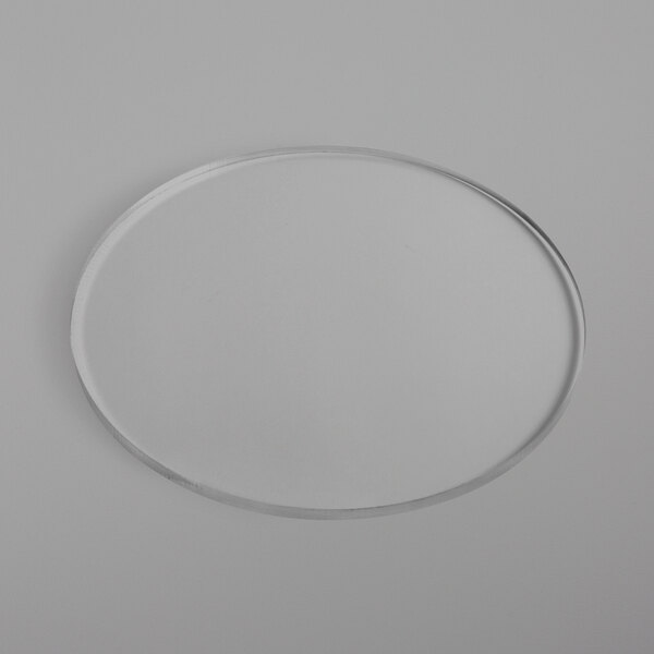 A clear circular plastic riser shelf on a white surface.
