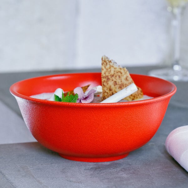A bowl of soup with a piece of food on it in a RAK Porcelain Neo Fusion Ember Red bowl.
