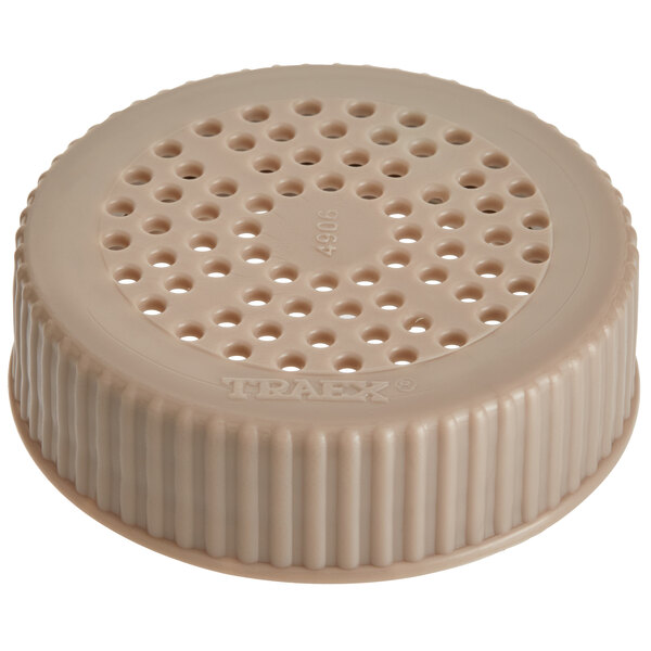 A beige plastic Vollrath Dripcut shaker lid with holes.