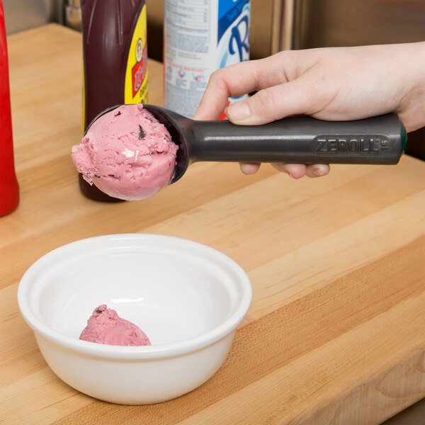 A hand scooping Zeroll ice cream into a bowl.