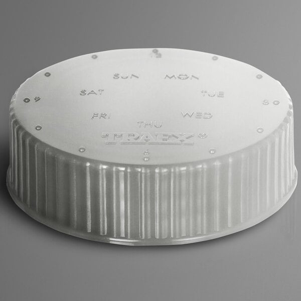 A white plastic Vollrath Dripcut lid with a metal rim and writing on the cap.