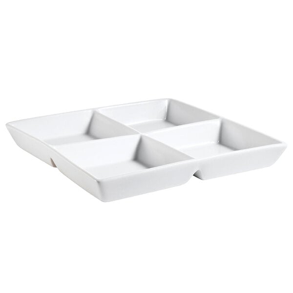 A bright white square porcelain dish with four compartments.
