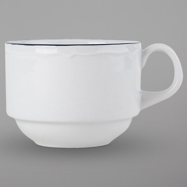 A white Tuxton china cup with a scalloped edge and a black rim with a blue line.