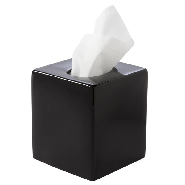 A black square ceramic tissue box cover with white tissue paper.