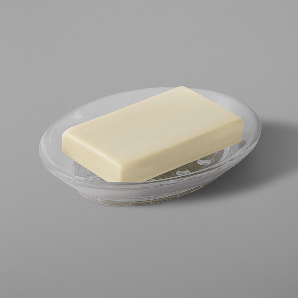 A piece of butter on a clear oval resin soap dish.