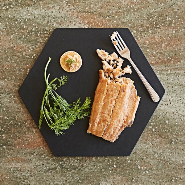 A slate Epicurean hexagon cutting and serving board with food on it.