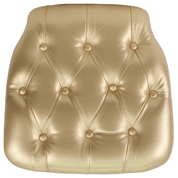 A gold vinyl tufted chair cushion with buttons on a white background.