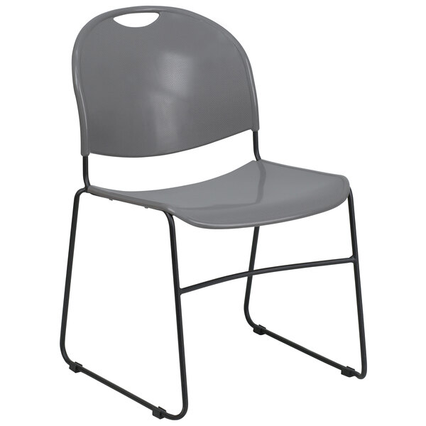 A Flash Furniture gray plastic stack chair with black legs.
