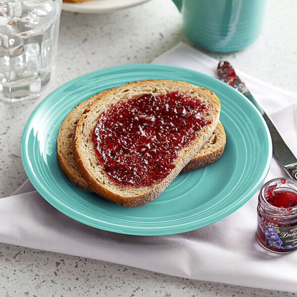 A Tuxton Concentrix Island Blue china plate with a piece of bread and jam on it.