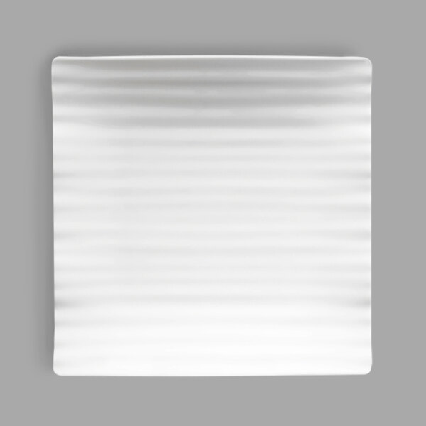 A white square plate with a ribbed surface.