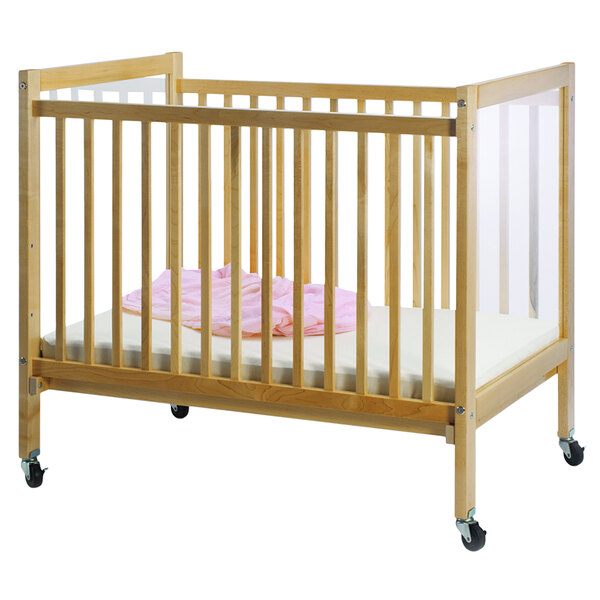A Whitney Brothers clear view wooden crib with a pink blanket on it.
