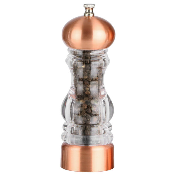 A Chef Specialties glass and copper pepper mill filled with pepper.