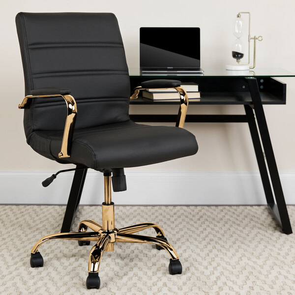 A Flash Furniture black leather mid-back office chair with gold legs and arms at a desk.