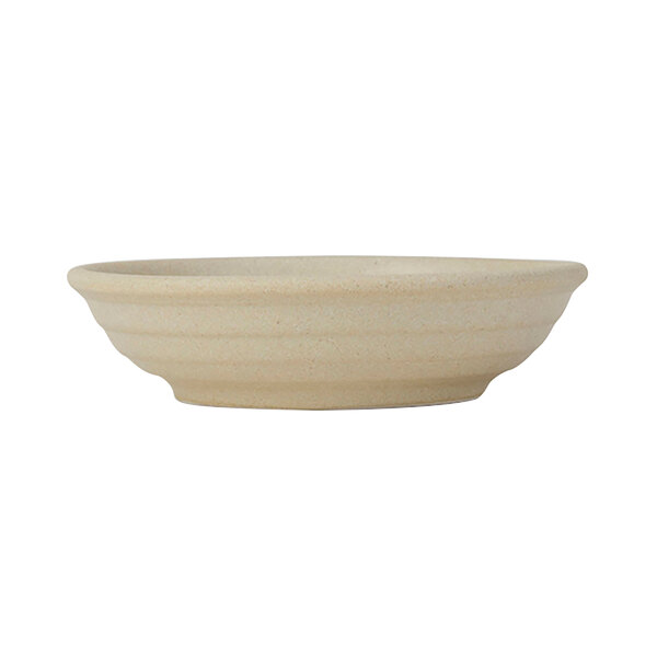 A Tuxton matte beige bowl with an embossed design on a white background.
