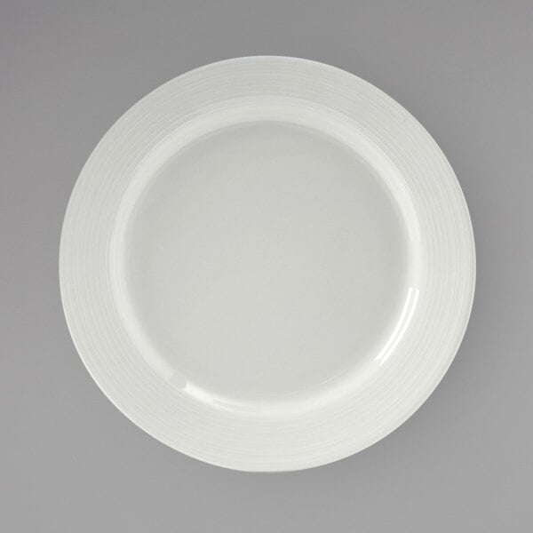 A Tuxton Pacifica bright white china plate with a curved edge.