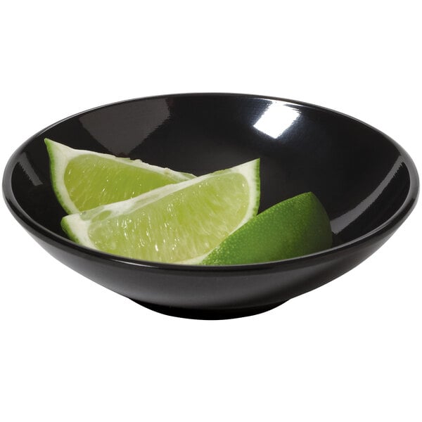 A black melamine bowl with lime wedges in it.