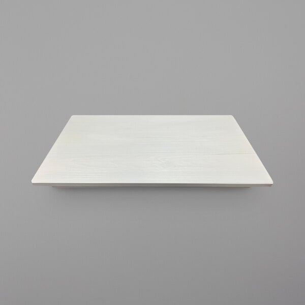 A white rectangular wood tray on a gray surface.