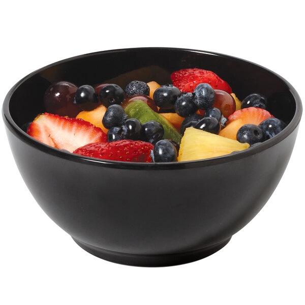 A black GET melamine bowl filled with fruit on a table.
