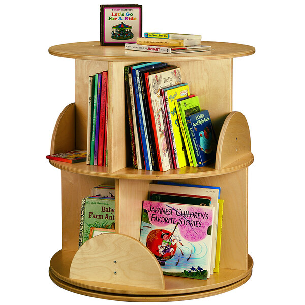 A Whitney Brothers round wooden book carousel with books on it.